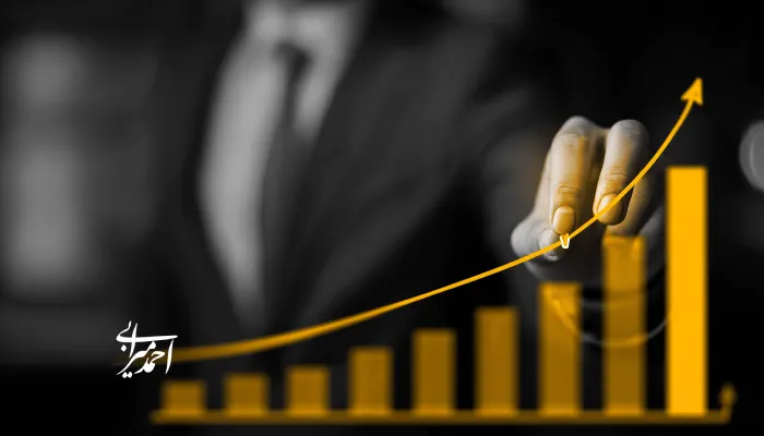 نموداری صعودی به رنگ زرد با دست مدیری در حال ترسیم خط رشد کسب‌وکار و موفقیت مالی.