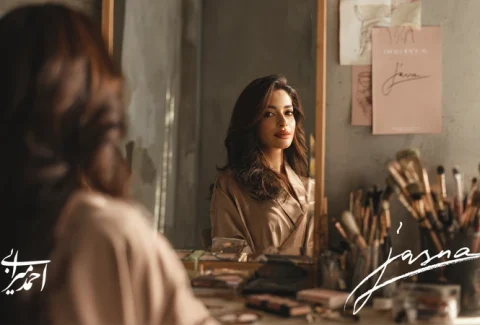 تصویر یک میکاپ‌آرتیست ایرانی مقابل آینه استودیو که گذار از خودآگاهی تا خلق امضای شخصی برند را با پالت رنگ رزگلد و مینیمال نشان می‌دهد