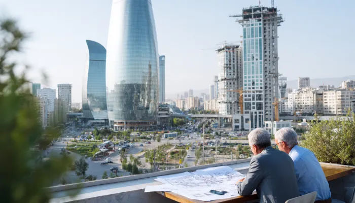 Два бизнес-руководителя анализируют планы развития и инвестиционные проекты на фоне современной городской застройки Тегерана и формирующейся деловой инфраструктуры.